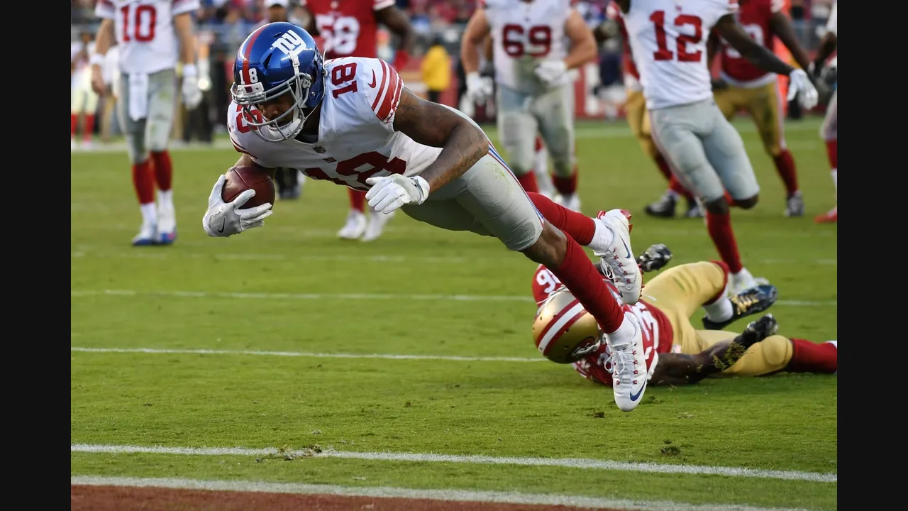 Photograph of a New York Giants receiver diving with the football against the San Francisco 49ers