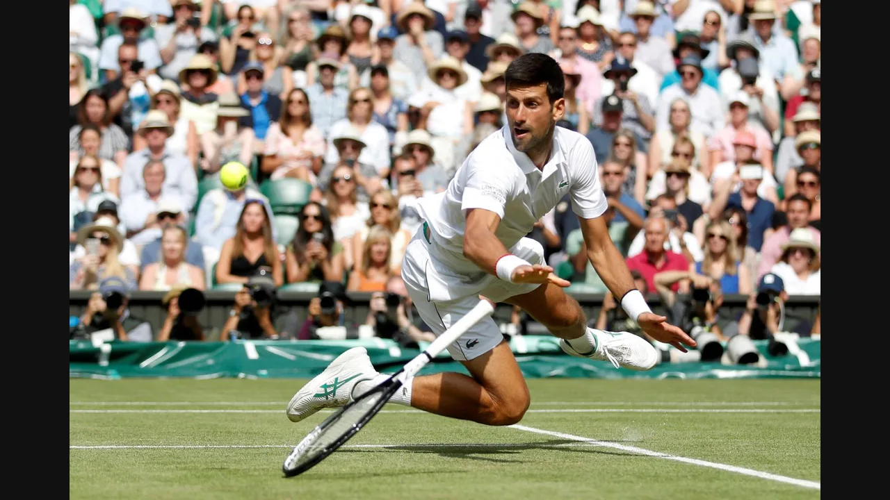 Photograph of Novak Djokovic lunging for a low shot on a grass court in front of a crowd