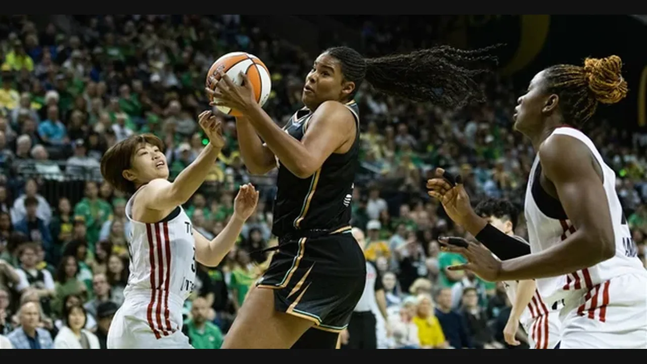 Photograph of women's basketball players contesting a drive to the basket in a packed arena